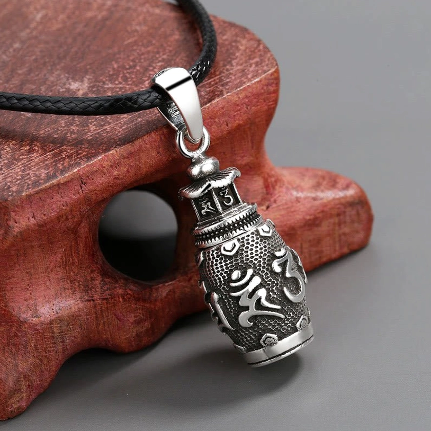 Buddhist six true words mantra copper pendant detail, 45-degree angle showing embossed engraved text and textured metal surface