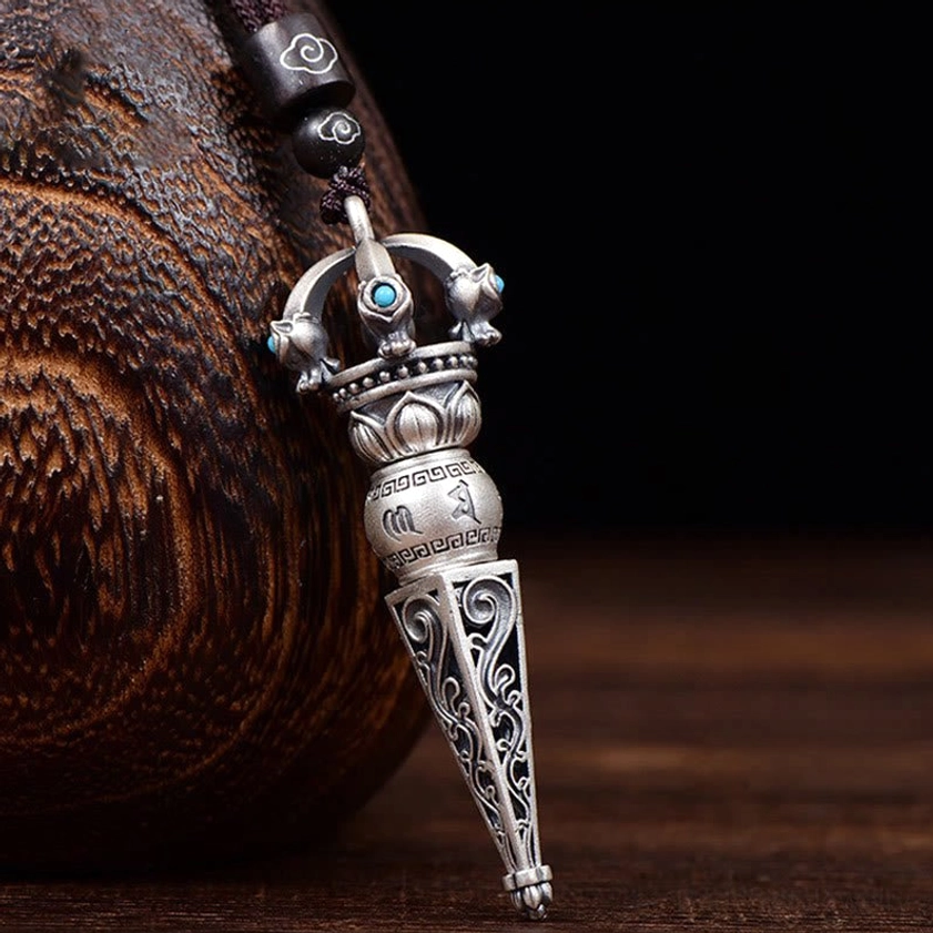 Rotatable Om Mani Padme Hum Dorje Vajra pendant necklace with turquoise inlays and carved Buddhist scriptures, displayed on wooden craft background