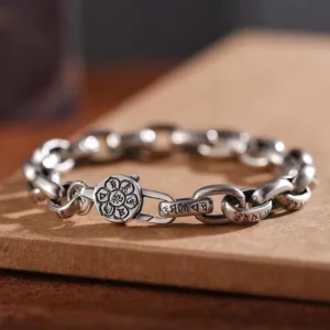 Om Mani Padme Hum Double Dorje copper bracelet with engraved mantra links and premium buckle clasp, side view on wooden board