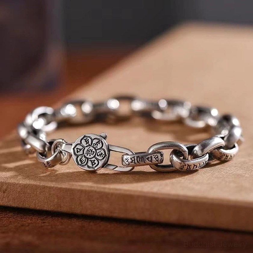Om Mani Padme Hum Double Dorje copper bracelet with engraved mantra links and premium buckle clasp, side view on wooden board