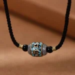 Om Mani Padme Hum Dzi Bead necklace front view with black braided rope and turquoise inlay