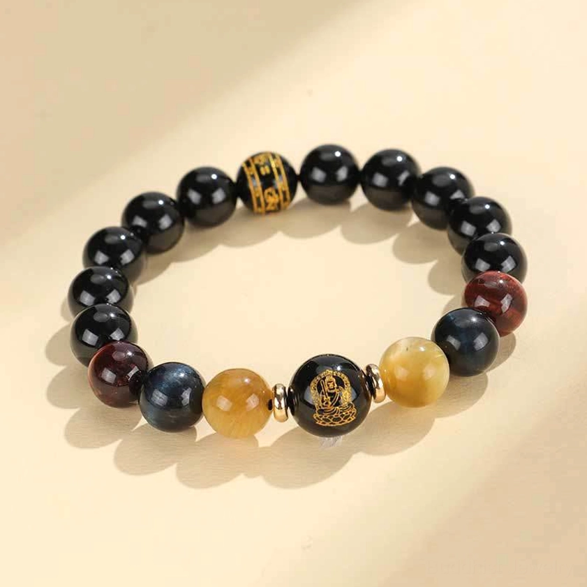 Close-up of black onyx tiger eye beads with engraved Om Mani Padme Hum mantra on zodiac natal Buddha charm