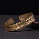 Om Mani Padme Hum brass cuff bracelet with lotus design and six true words mantra engraving, vintage patina finish