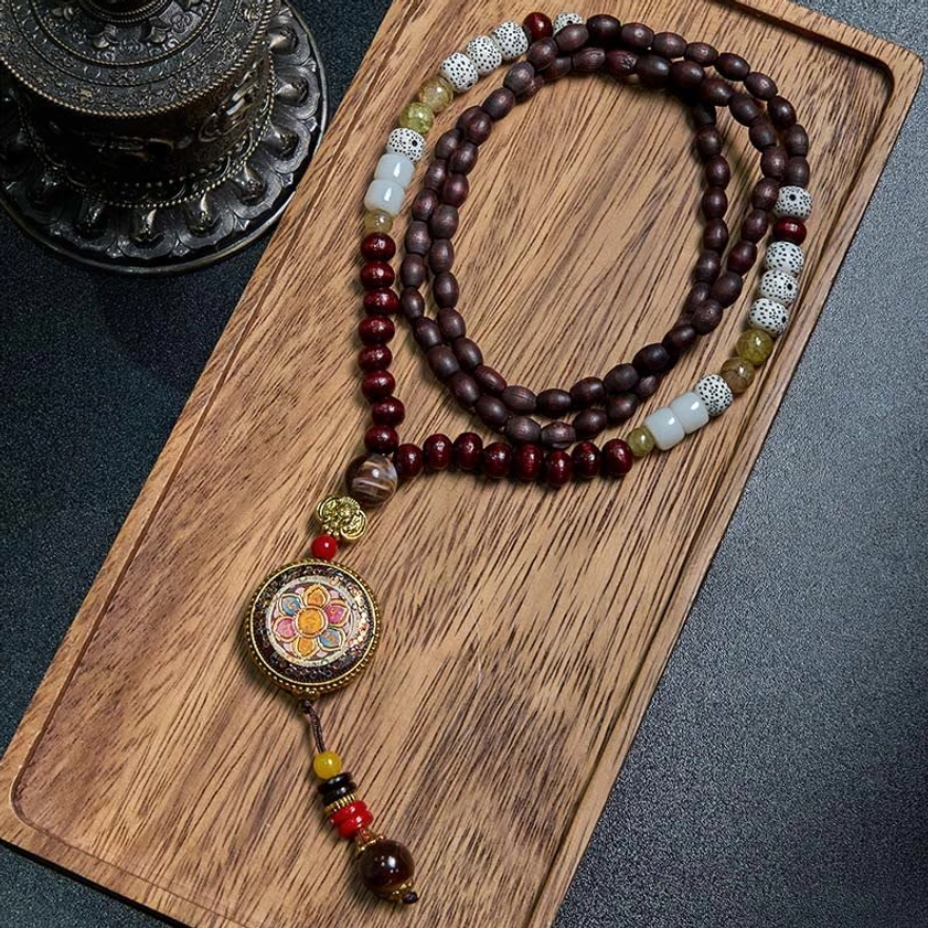 Handmade Buddhist wood bead mala necklace with enamel deity pendant, alternative angle overhead view