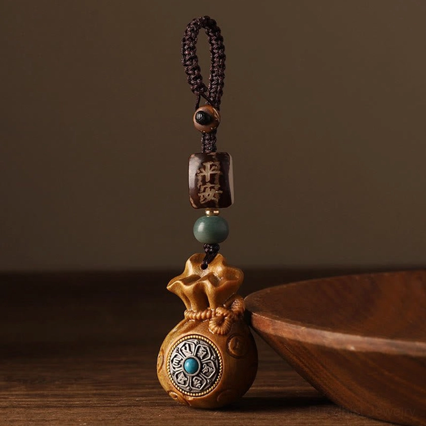 Sacred Buddhist money bag charm featuring Om Mani Padme Hum mantra inscription with sandalwood material detail
