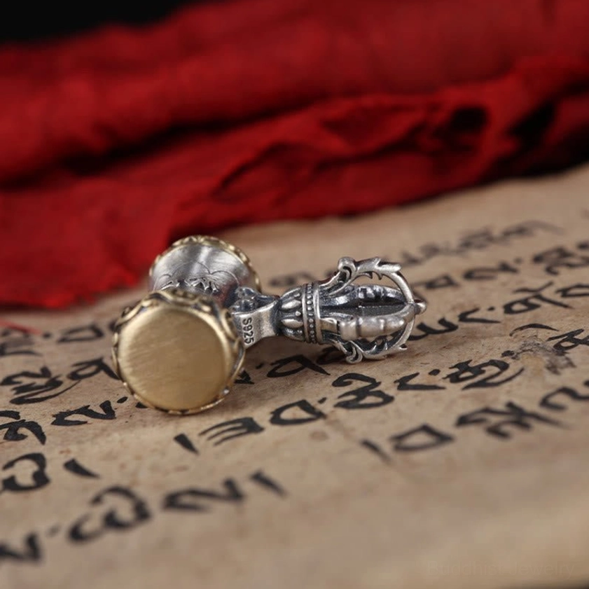 Close-up detail of Om Mani Padme Hum sacred mantra engraving on sterling silver vajra bell pendant