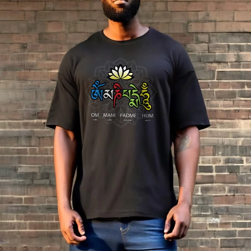 Person wearing black Om Mani Padme Hum lotus tee in streetwear style with blue denim pants against brick wall