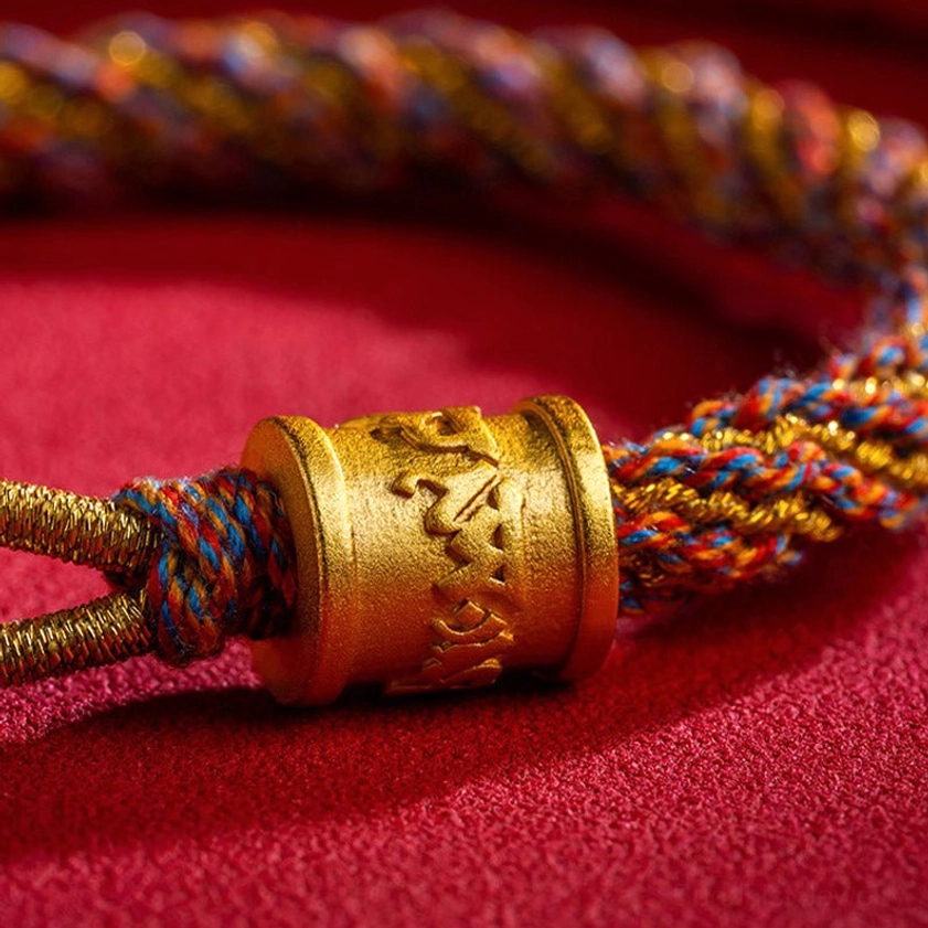 Carved Om Mani Padme Hum mantra on gold-toned metal tube bead with braided rope