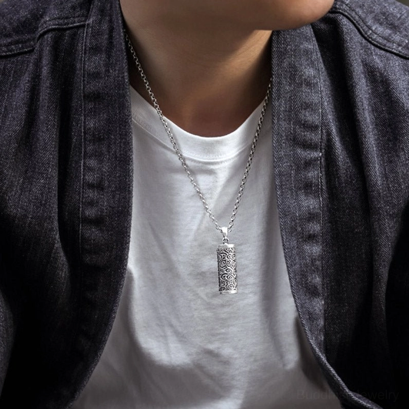 Buddhist protection necklace worn with denim jacket and white t-shirt - vintage silver finish cylinder pendant at chest