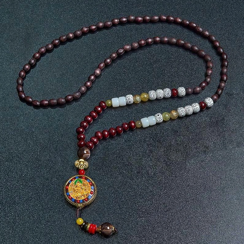 Handmade wood bead Buddhist necklace with mixed spacer beads and deity pendant, flat lay