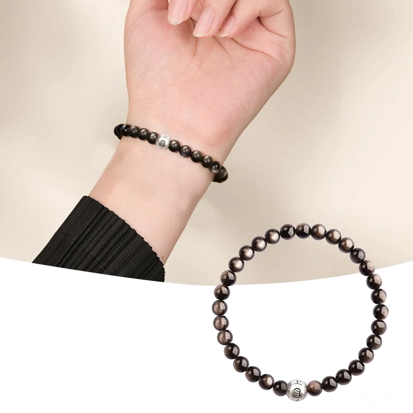 Silver Sheen Obsidian protection bracelet worn on slim wrist with engraved mantra charm, close-up lifestyle shot