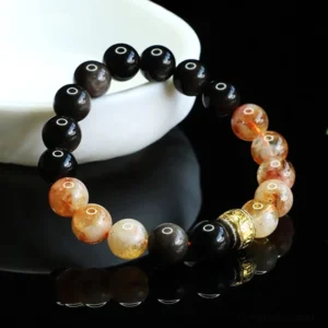 Om Mani Padme Hum silver sheen obsidian citrine protection bracelet displayed on white ceramic dish with engraved gold spacer bead
