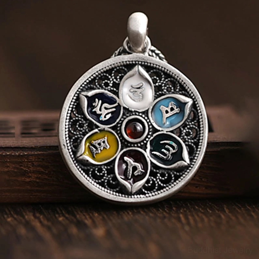 Buddhist Om Mani Padme Hum mantra pendant close-up showing red gemstone center and lotus-shaped enamel frames