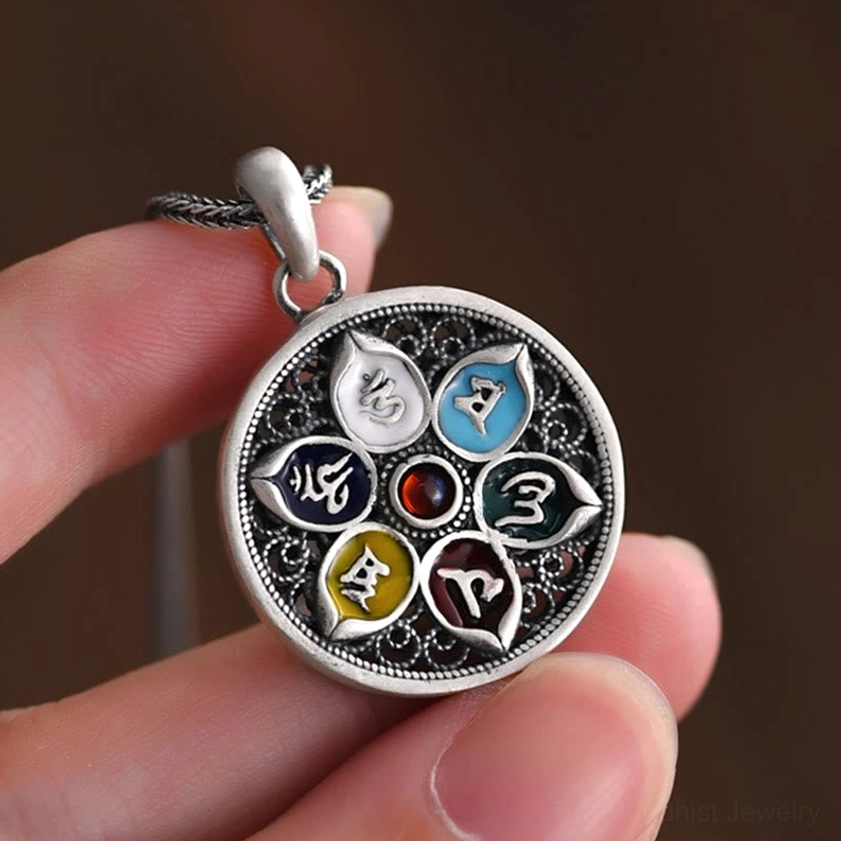 Hand-held Om Mani Padme Hum silver pendant showing detailed filigree work and craftsmanship