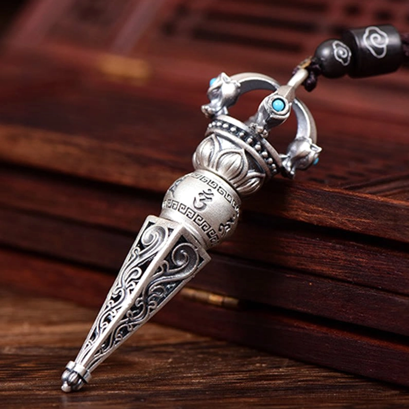 Overhead view of Om Mani Padme Hum pendant necklace highlighting hollowed crown top and circular scripture carvings
