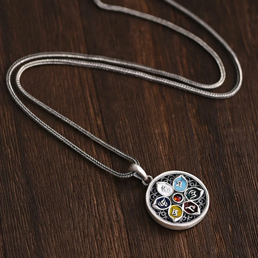 Reverse side of Om Mani Padme Hum pendant showing engraved mantra characters and silver craftsmanship