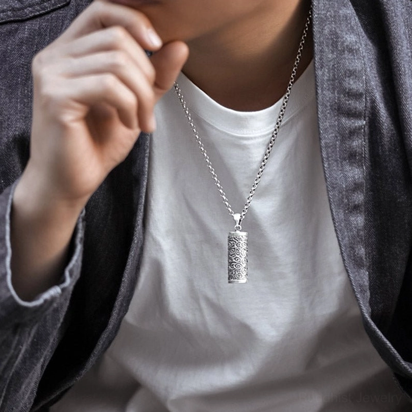 Side view of Om Mani Padme Hum Buddhist necklace pendant worn at collarbone - delicate silver chain and carved mantra details