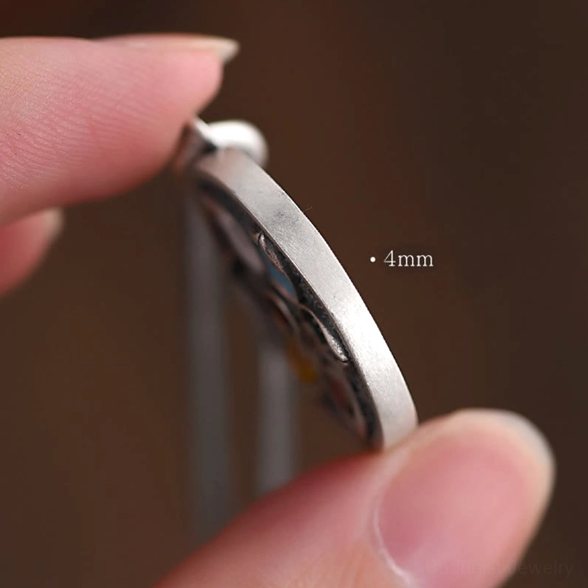 Side view of Om Mani Padme Hum silver pendant showing 4mm thickness and rounded smooth edges