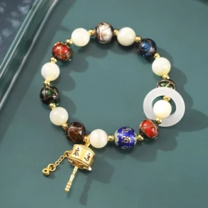 Om Mani Padme Hum prayer wheel bracelet with incense ash liuli glass and tridacna stone beads, flat lay on dark tray showing all materials