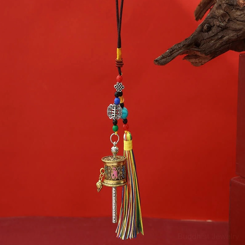 Light antique gold Om Mani Padme Hum prayer wheel keychain with subtle patina and beaded rope decoration
