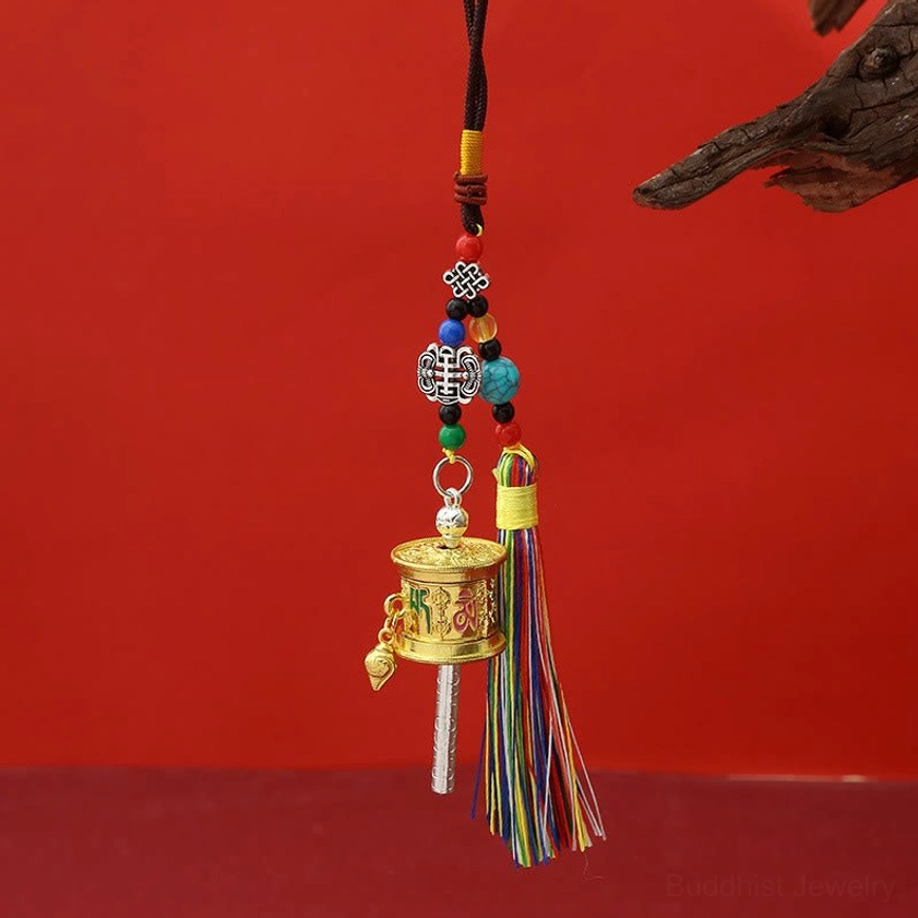 Light gold polished Om Mani Padme Hum prayer wheel keychain with bright finish and colorful tassel strands