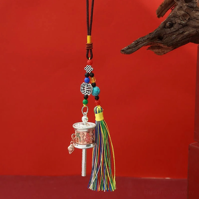Bright red copper Om Mani Padme Hum prayer wheel keychain with colorful tassels and beaded accents