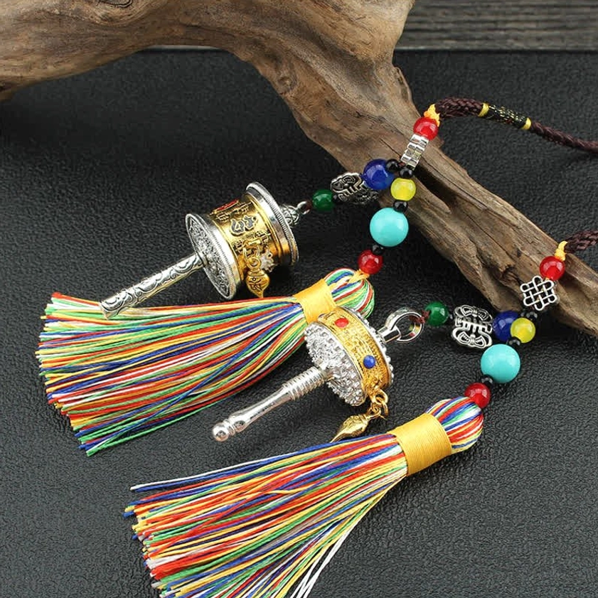Multiple Om Mani Padme Hum prayer wheels in mixed gold and silver tones with rainbow tassels