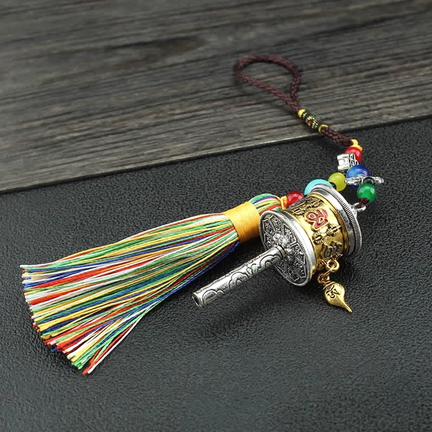 Silver-toned Om Mani Padme Hum prayer wheel with rainbow tassel hanging ornament side view