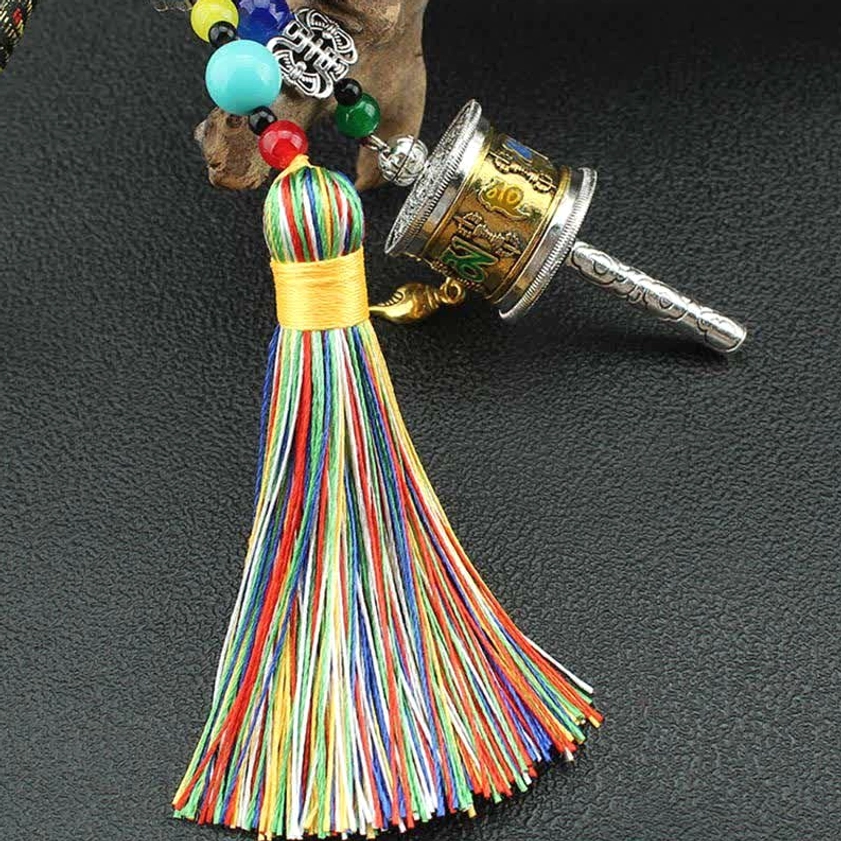 Om Mani Padme Hum prayer wheel with yellow-wrapped rainbow tassel and engraved metal shaft