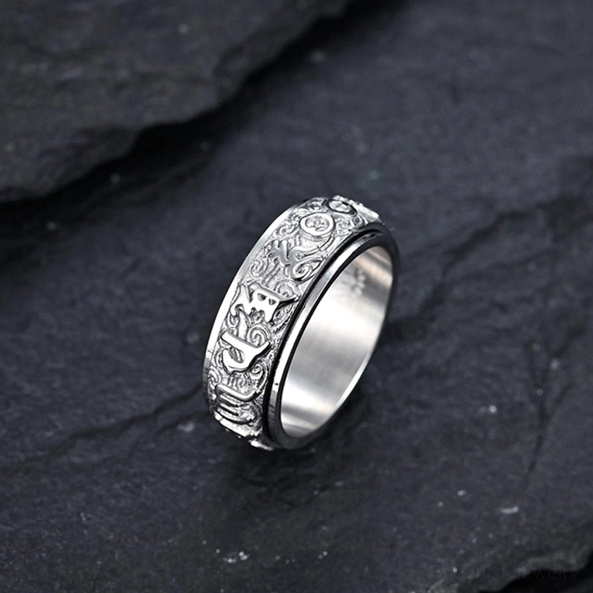 Buddhist Om Mani Padme Hum titanium steel spinner ring detailed close-up showing Sanskrit engravings and rotating band mechanism
