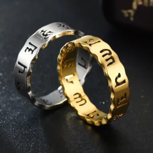 Couple wearing black and golden om mani padme hum titanium steel meditation rings with wavy band design on dark reflective surface
