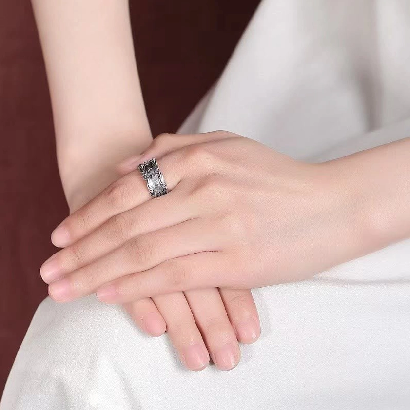 Om Mani Padme Hum silver ring close-up worn on hand showing adjustable open design and detailed mantra carving on index finger