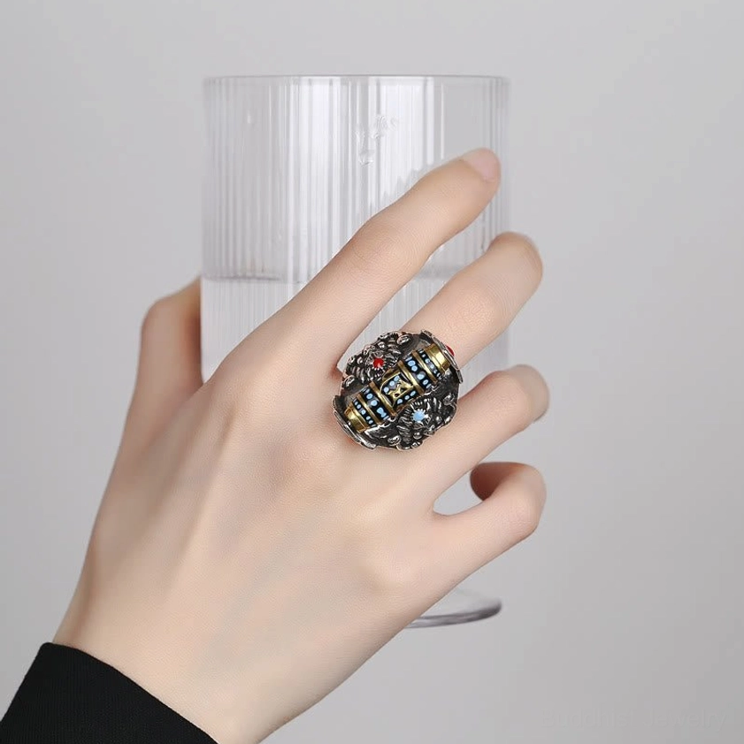 Buddhist mantra ring worn on hand showing silver-toned metal finish and Dzi bead pattern in authentic wear