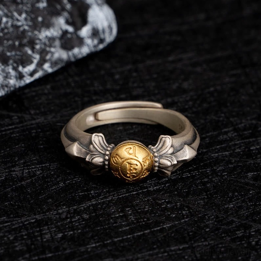 Buddhist Om Mani Padme Hum sterling silver ring overhead view showing two-tone silver and gold design on black fabric