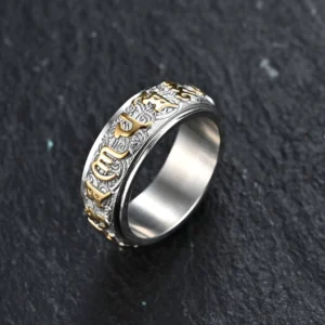 Six True Words Om Mani Padme Hum titanium steel spinner ring with silver-gold two-tone finish, embossed Sanskrit engravings, side view on dark stone background
