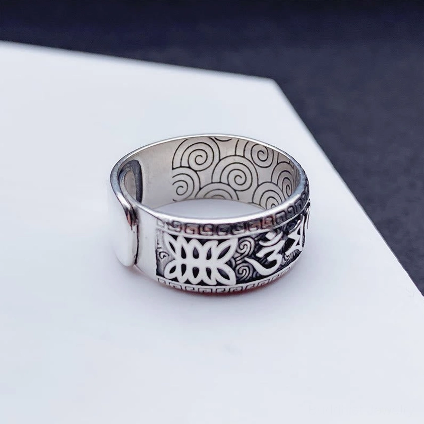 Detailed view of carved Om Mani Padme Hum copper ring showing spiral patterns and embossed design