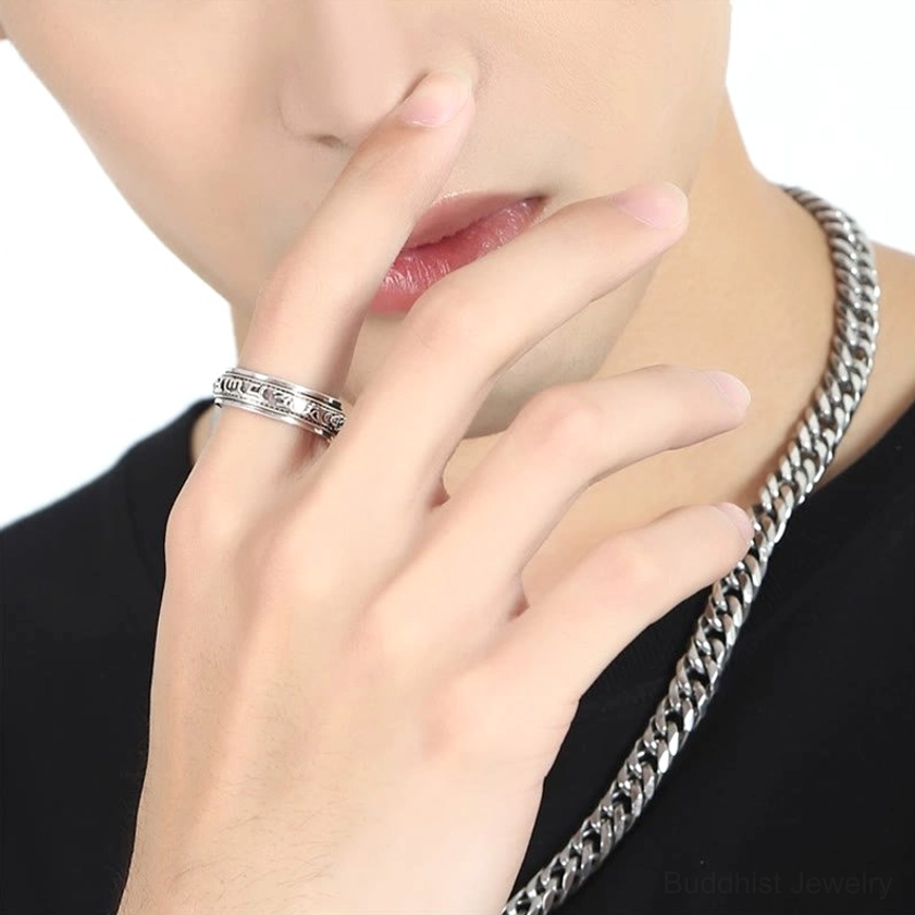 Worn on hand - Om Mani Padme Hum rotatable ring displayed on index finger showing vintage religious ring style in casual setting