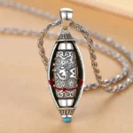 Om Mani Padme Hum rotatable mantra pendant necklace with 360 degree rotating inner core, vintage silver finish with blue stone accent, overhead close-up view