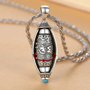 Om Mani Padme Hum rotatable mantra pendant necklace with 360 degree rotating inner core, vintage silver finish with blue stone accent, overhead close-up view
