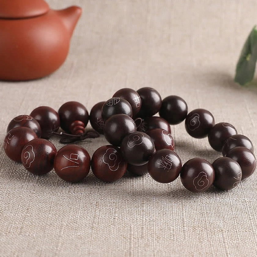Red sandalwood Om Mani Padme Hum bracelet with 925 sterling silver inlay displayed on spiritual meditation background