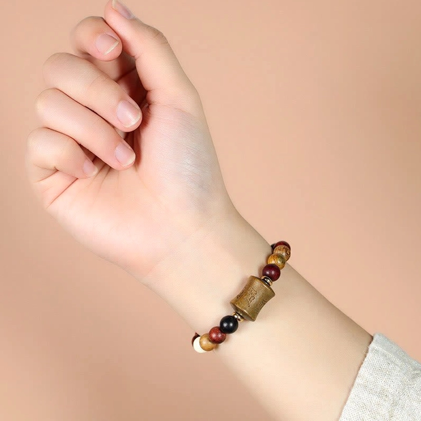 Multicolor sandalwood Om Mani Padme Hum bracelet worn on wrist, side profile showing slim fit and bead arrangement