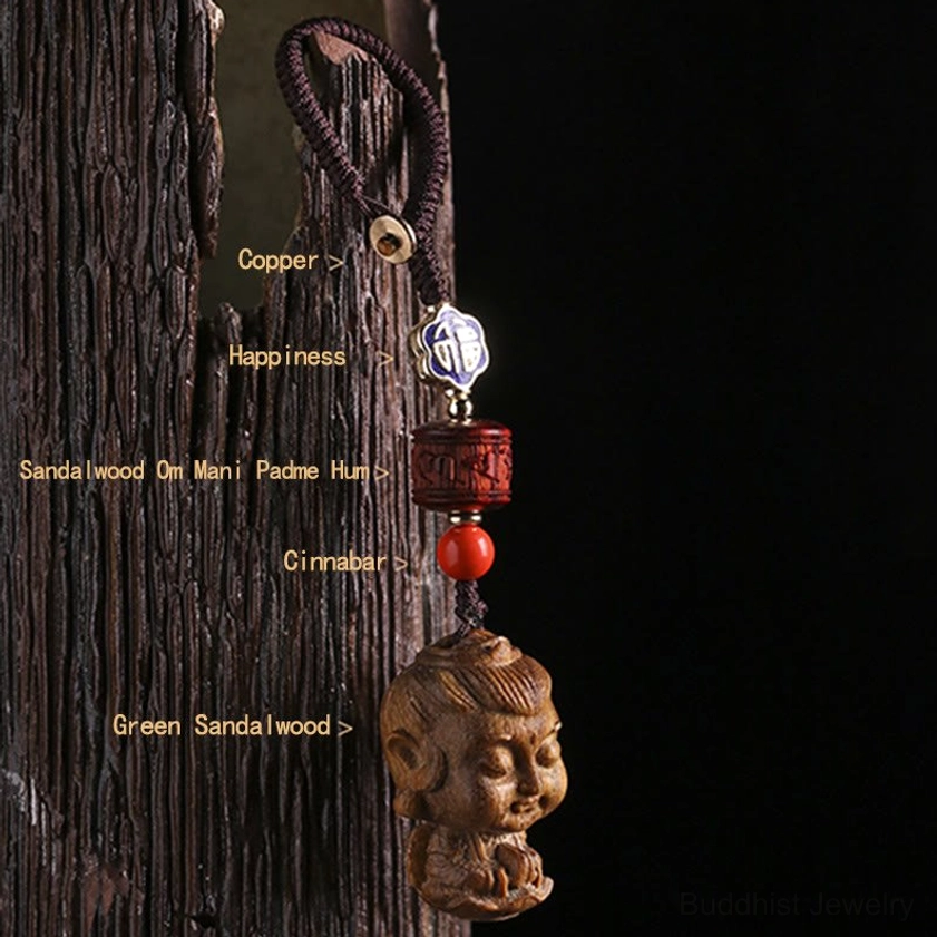 Buddhist keychain with Om Mani Padme Hum mantra green sandalwood copper and cinnabar materials close-up