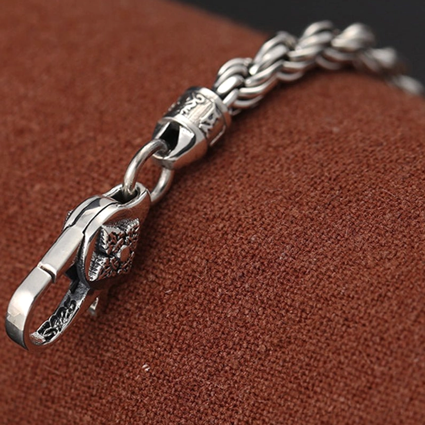 Close-up detail of om mani padme hum double dorje silver bracelet engraved decorative clasp and joint