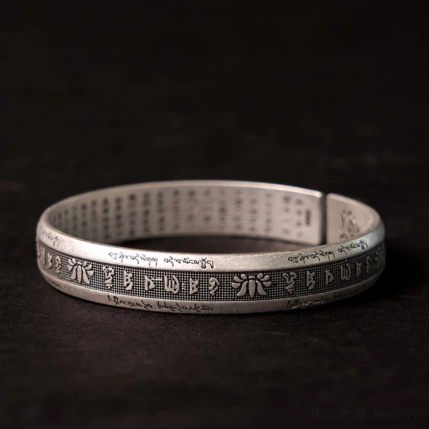 Om Mani Padme Hum meditation bracelet with full outer engraving, flat lay view on dark background