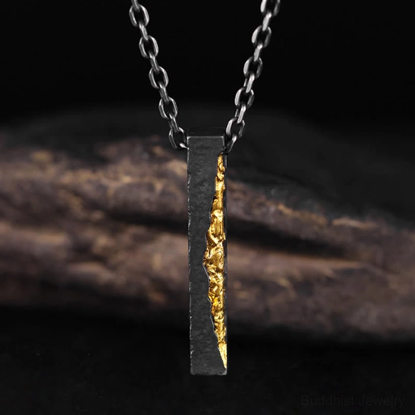 Om Mani Padme Hum pendant in sterling silver with gold inlay, low front angle close-up displaying oxidized finish and carved mantra clarity