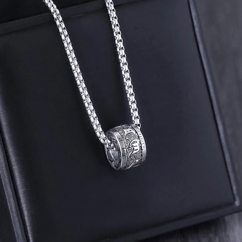 All-silver Om Mani Padme Hum necklace with wheat link chain, side oblique view on black leather display surface