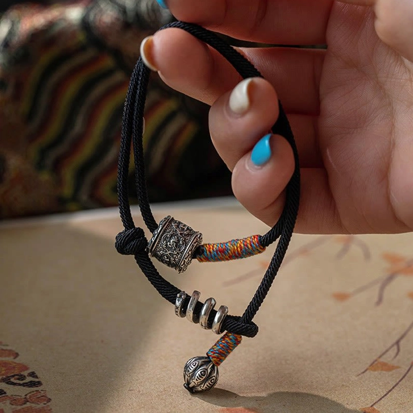Buddhist spiritual bracelet Om Mani Padme Hum with woven textile accents and silver decorative elements