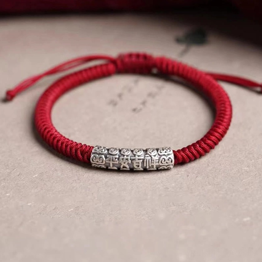 Om Mani Padme Hum sterling silver string bracelet with braided red cord showing adjustable closure