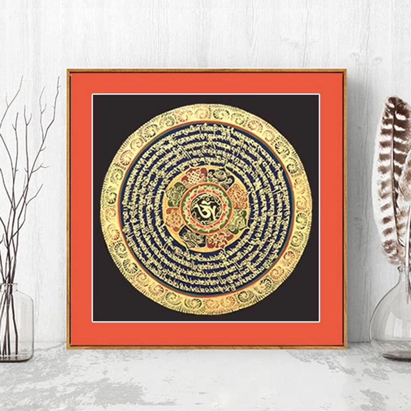 Hand-painted Buddhist thangka scroll with Om Mani Padme Hum mantra in gilded mandala design on black background, displayed in minimalist living room with red frame
