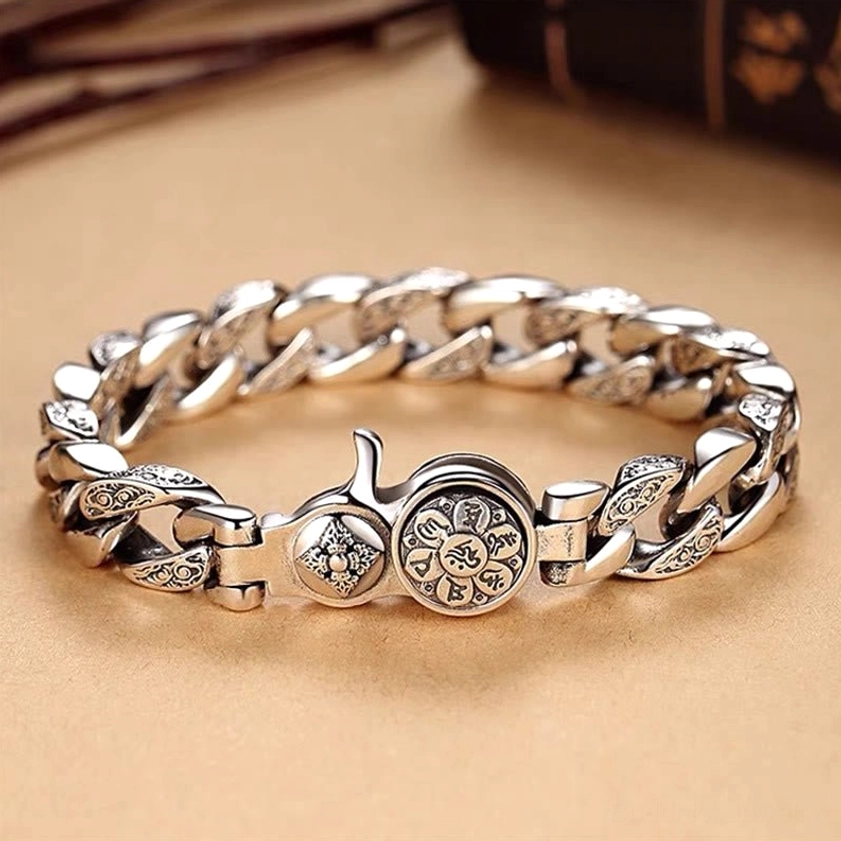 Om Mani Padme Hum Double Dorje Vajra bracelet top view flat lay showing engraved silver curb chain with round vajra emblem